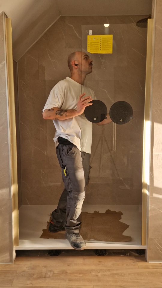 Pose d'une paroi de douche dans une salle de bain en marbre